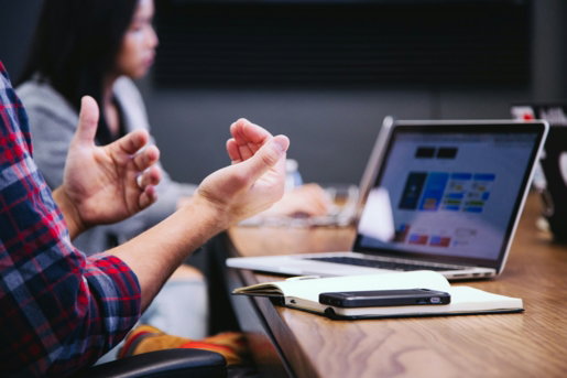 person-gesturing-during-meeting-with-laptop.jpg person gesturing during meeting with laptop
